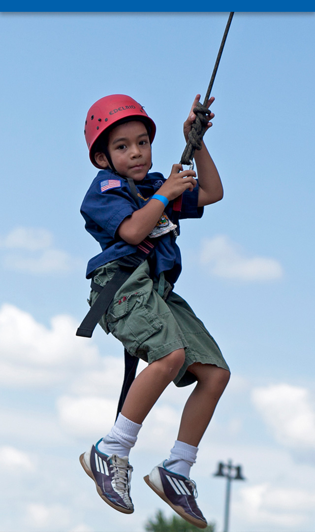 Young Scout flying through the air while hanging from a harness